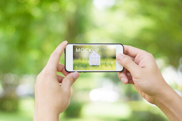 A man is holding cell phone on green , Mockup business template