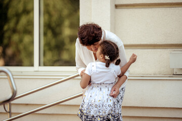 Summer portrait of happy grandmother with granddaughter outdoors.