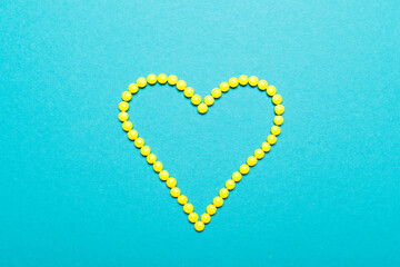 Symbol heart from colors  pills medicament and different pills inside on blue background 