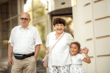 Obraz premium Grandparents playing with their granddaughter