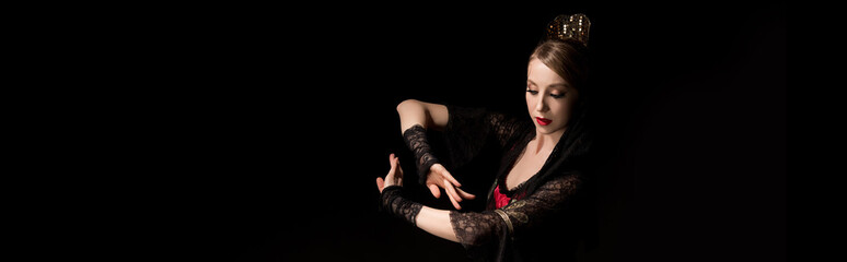 panoramic concept of attractive dancer in dress gesturing while dancing flamenco isolated on black