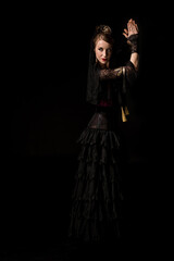 attractive young flamenco dancer dancing and clapping hands isolated on black