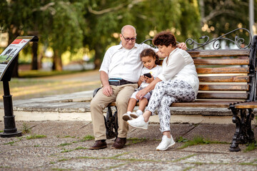 Naklejka na ściany i meble Grandparents playing with their granddaughter