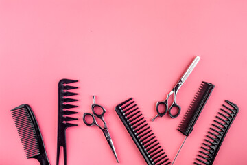 Combs, hairbrush, scissors on pink desk from above copy space
