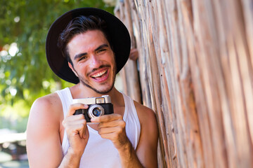 Hipster young man with vintage camera outdoors