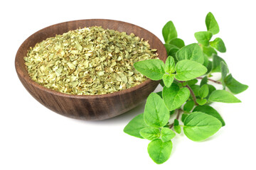 dried oregano flakes in the wooden bowl, with fresh oregano leaves, isolated on white background