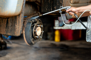 Old rusty brake system in the car have to clean with high pressure water gun.