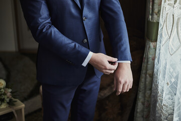 Businessman wears a jacket, male hands closeup,groom getting ready in the morning before wedding...