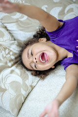 Obraz na płótnie Canvas Cheerful small girl showing her tongue.