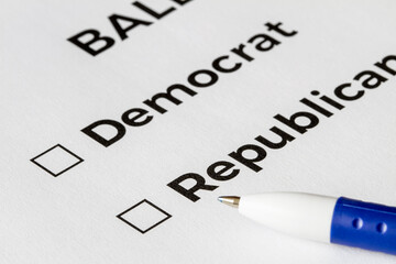 Obraz premium Checklist concept. Closeup of ballot paper with words Democrat and Republican with checkboxes and pen on it.