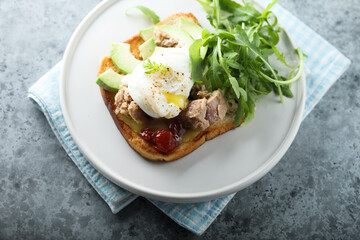 Poached egg with tuna and arugula on toast