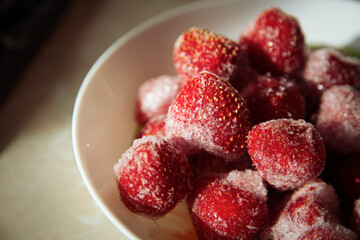A full plate of strawberries covered in frost