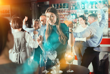 Girl drinking cocktail and dancing