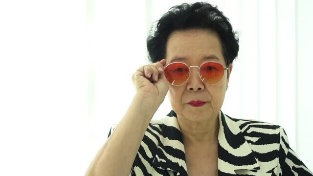 Asian senior elderly model stylish fashion summer sunglasses and zebra animal print dress