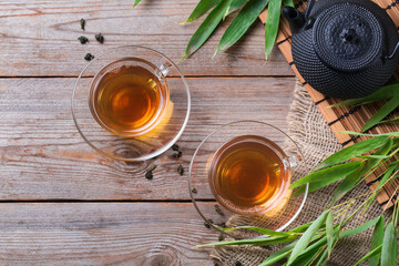 Cup of hot green tea on a wooden table