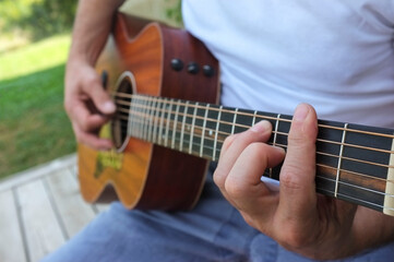 Fototapeta na wymiar Close up of man playing guitar outdoor