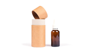 Bottle of essential oil, collagen or hyaluronic acid with paper tube packaging isolated on white. Mockup and copyspace for your design or text. Modern beauty and apothecary concept
