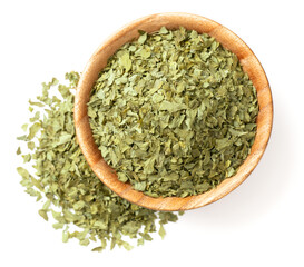 dried parsley flakes in the wooden bowl, isolated on white background, rop view