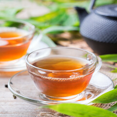 Cup of hot green tea on a wooden table