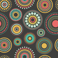 Fototapeta premium Seamless abstract pattern of blue, orange and green circles and dots on black background.
