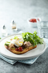 Poached egg with tuna and arugula on toast