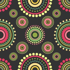 Seamless abstract pattern of red, orange and green circles and dots on black background. Kaleidoscope ornament.