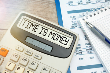 Inscription TIME IS MONEY on calculator. Business and technology concept.