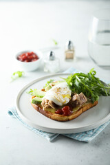Poached egg with tuna and arugula on toast