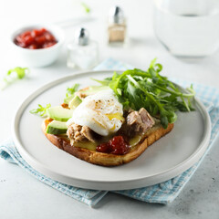 Poached egg with tuna and arugula on toast
