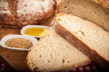 rebanadas de pan masa madre artesano con decoración de aceite y especias sobre fondo de madera