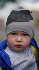 Baby son in dad's arms in park, close-up