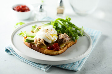 Poached egg with tuna and arugula on toast