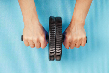 Sports blue roll for training the abs in the hands.