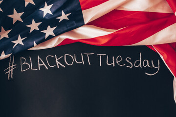 Fototapeta na wymiar Hashtag Blackout Tuesday inscription on a black background with American flag around. Black lives matter, blackout tuesday2020 concept. Toned.