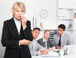 Business team solving problems with upset woman foreground