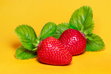 Strawberries with leaves. On a yellow background.