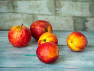 Fresh fruits yellow-red apples and nectarines on a plank table