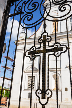 Orthodox cross forged in fence of church. Christian religion pattern. Entrance to the temple. Religious holiday or Sunday service.