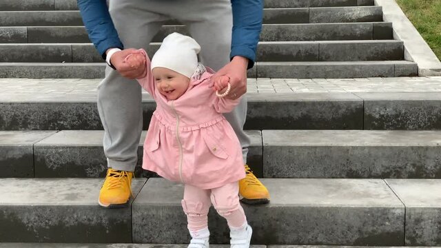 One year old girl with father climb up on the on stairs