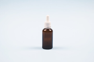 Fototapeta premium Bottle of essential oil, collagen or hyaluronic acid on light blue background. Mockup and copyspace for your design or text. Modern beauty and apothecary concept