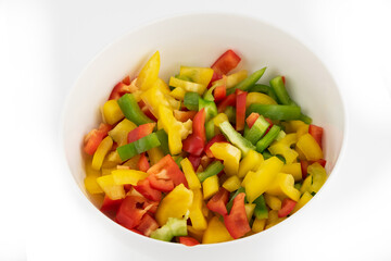 Bowl of mixed bell peppers isolated on a white background