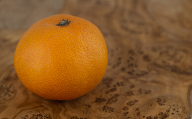 Whole Satsuma Mandarine on a wooden board with an intricate pattern