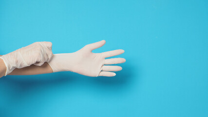 Hand wearing white gloves and the right hand is pulling. Put on a blue or turquoise background.