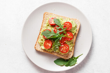 Avocado toast with cherry tomatoes and arugula.