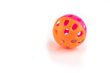 Orange and pink cat toy ball with a bell inside, isolated on a white background