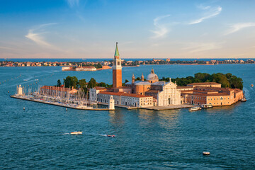 Fototapeta na wymiar Famous Italy tourist destination - aerial view of Venice lagoon and San Giorgio di Maggiore church with boats and vaporetto traffic on sunset from St Mark's Campanile bell tower, Venice, Italy