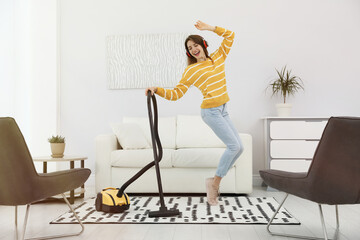 Young woman having fun while vacuuming at home