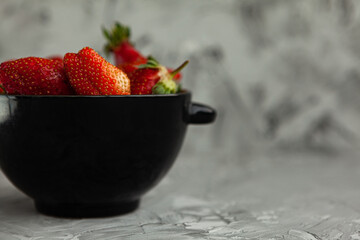 Ripe red strawberries. Bowl filled with juicy fresh ripe red strawberries. strawberries on a grey concrete table. Fresh strawberries photo. Сoncept healthy food
