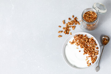 Homemade oatmeal granola bowl with greek yogurt on bright background.