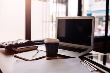 Office workplace with laptop, calculator, book and document on wood table
